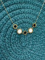 "Anti-tarnish gold necklace with Roman numeral charms and alternating black and white stones"