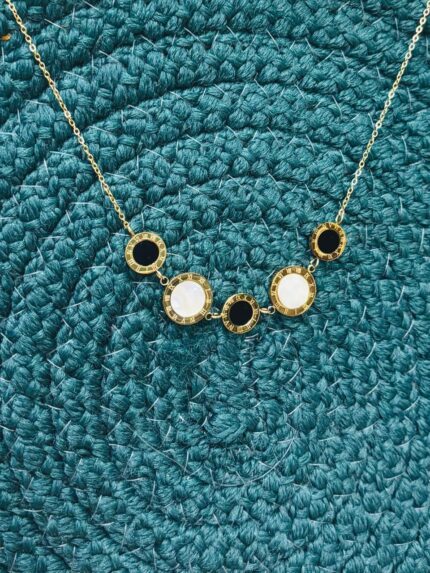 "Anti-tarnish gold necklace with Roman numeral charms and alternating black and white stones"